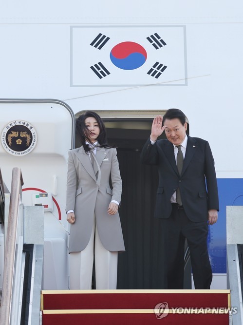 3月16日，在位于京畿道城南市的首尔机场，韩国总统尹锡悦（右）和夫人金建希启程前往日本。图为尹锡悦伉俪在搭乘总统专机“空军一号”前向送行人士致意。 韩联社