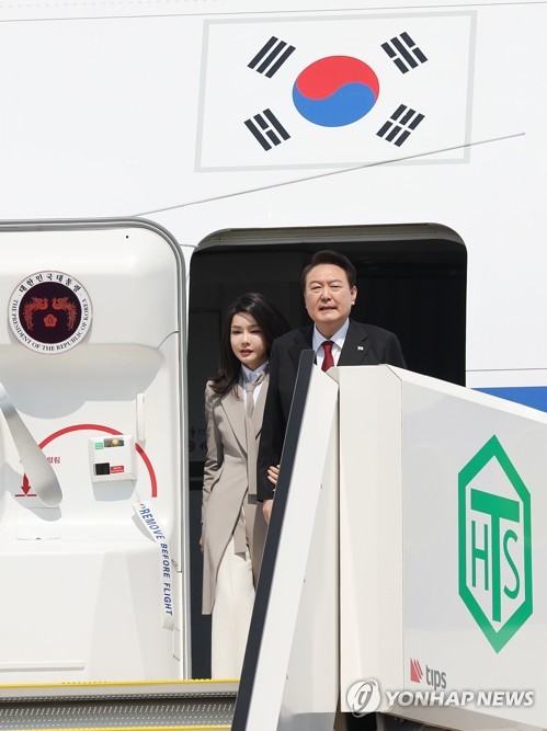 3月16日，韩国总统尹锡悦（右）和夫人金建希抵达东京羽田机场，开始为期2天的访日行程。图为尹锡悦伉俪正在下机。 韩联社