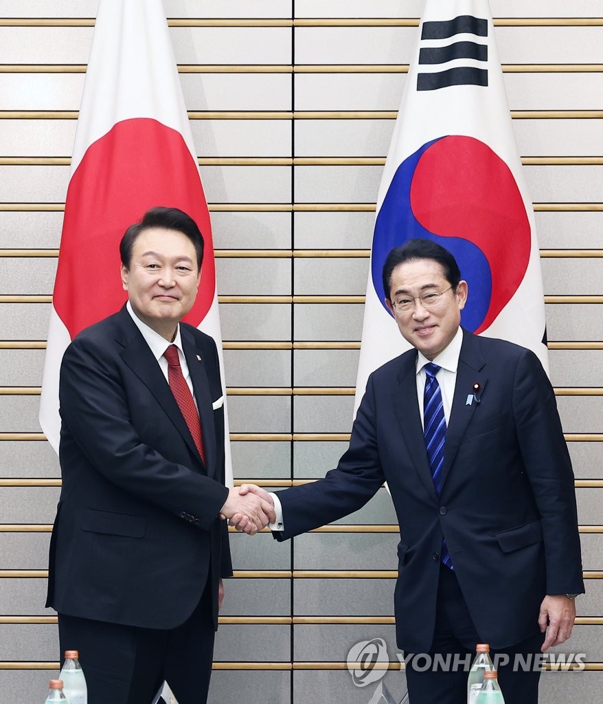 3月16日，在位于东京的日本首相官邸，韩国总统尹锡悦（左）同日本首相岸田文雄举行首脑会谈。图为两位领导人在扩大会谈前握手合影。 韩联社
