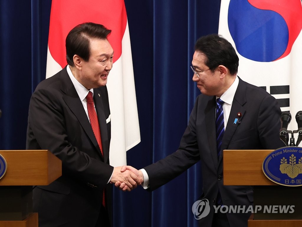 3月16日下午，在日本东京的首相官邸，韩国总统尹锡悦（左）和日本首相岸田文雄举行会谈。图为两位领导人在结束联合记者会后握手致意。 韩联社