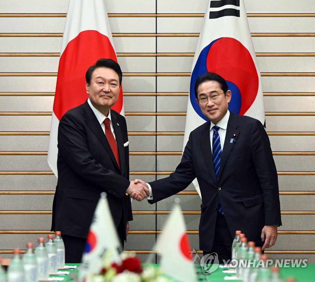 3月16日，在位于东京的日本首相官邸，韩国总统尹锡悦（左）同日本首相岸田文雄在举行扩大会谈前握手致意。 韩联社