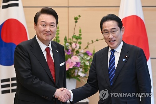 3月16日下午，在位于东京的日本首相官邸，韩国总统尹锡悦（左）同日本首相岸田文雄在举行小范围会谈前握手合影。 韩联社