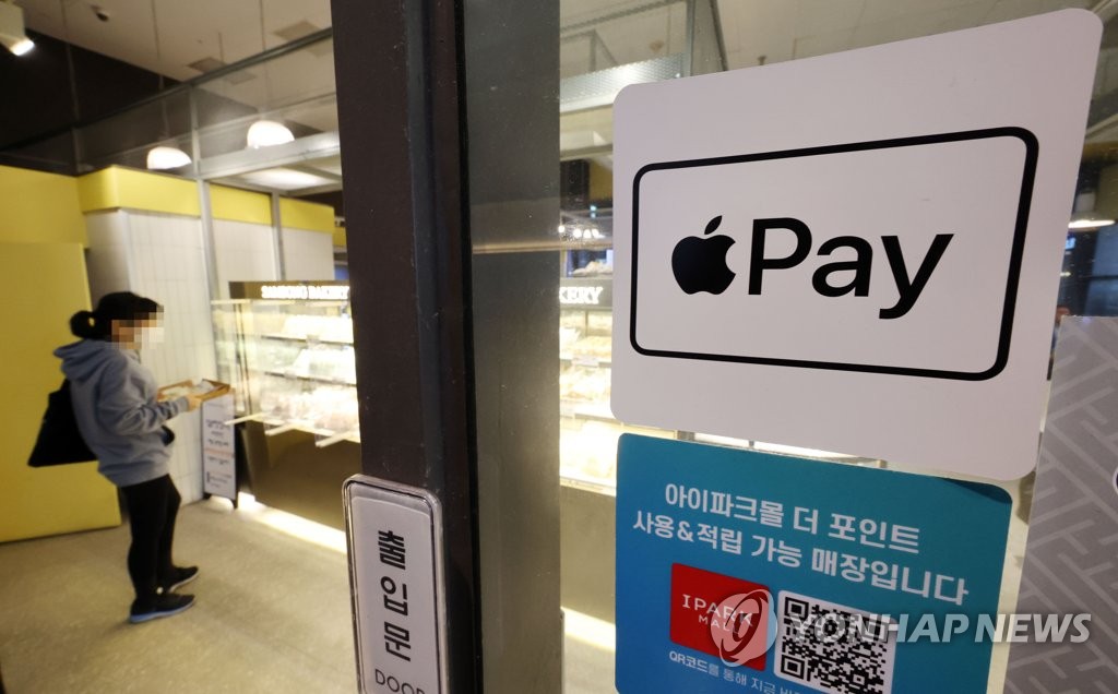 资料图片：一商家贴出支持苹果支付的告示。 韩联社