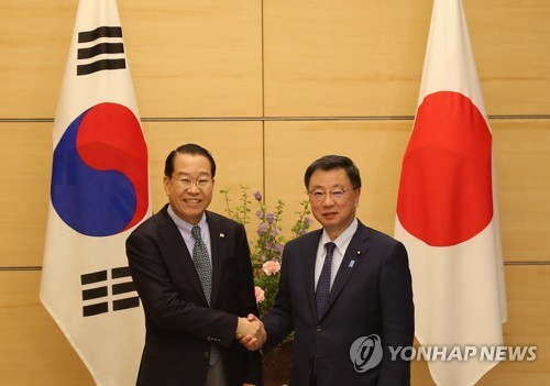 3月23日，在日本东京，权宁世（左）与日本内阁官房长官松野博一在举行会晤前合影留念。 韩联社