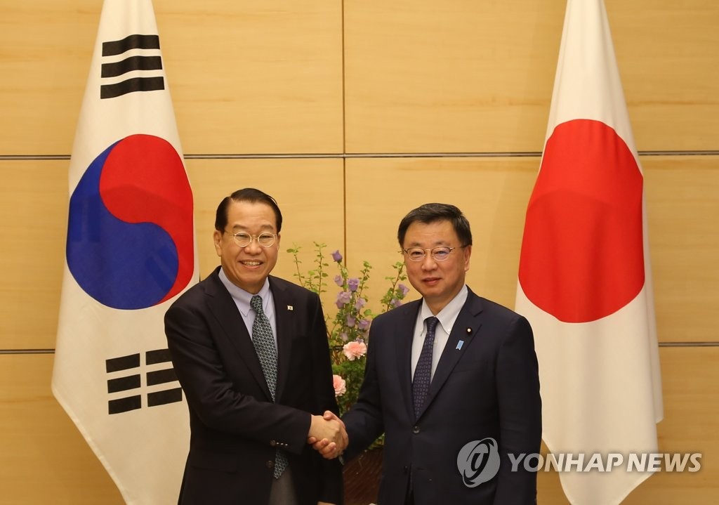 3月23日，在日本东京的首相官邸，权宁世（左）会见日本内阁官房长官松野博一。 韩联社
