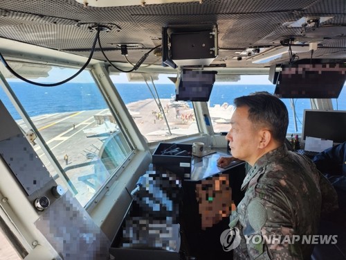 3月27日，在济州岛以南公海，韩国联参议长金承谦登上美国“尼米兹”号核动力航母舰（CVN-68）对韩美联合海上演习进行现场指导。 韩联社/联参供图（图片严禁转载复制）