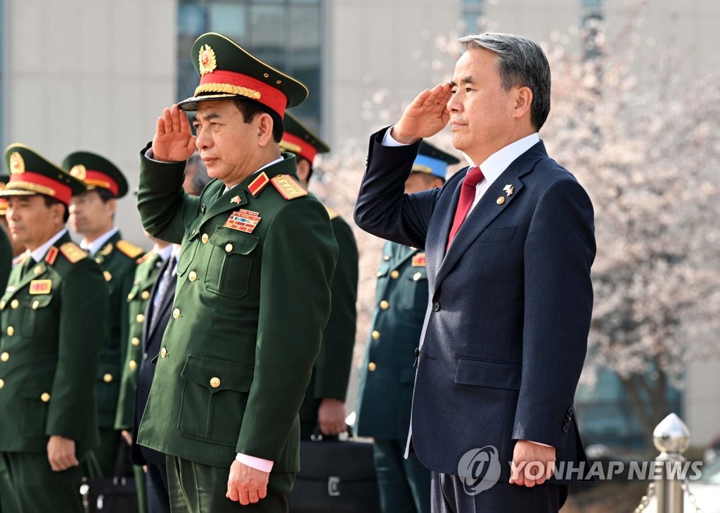 3月28日，在首尔龙山区的国防部大楼前，韩国国防部长官李钟燮（右）与越南国防部长潘文江共同检阅仪仗队。 韩联社