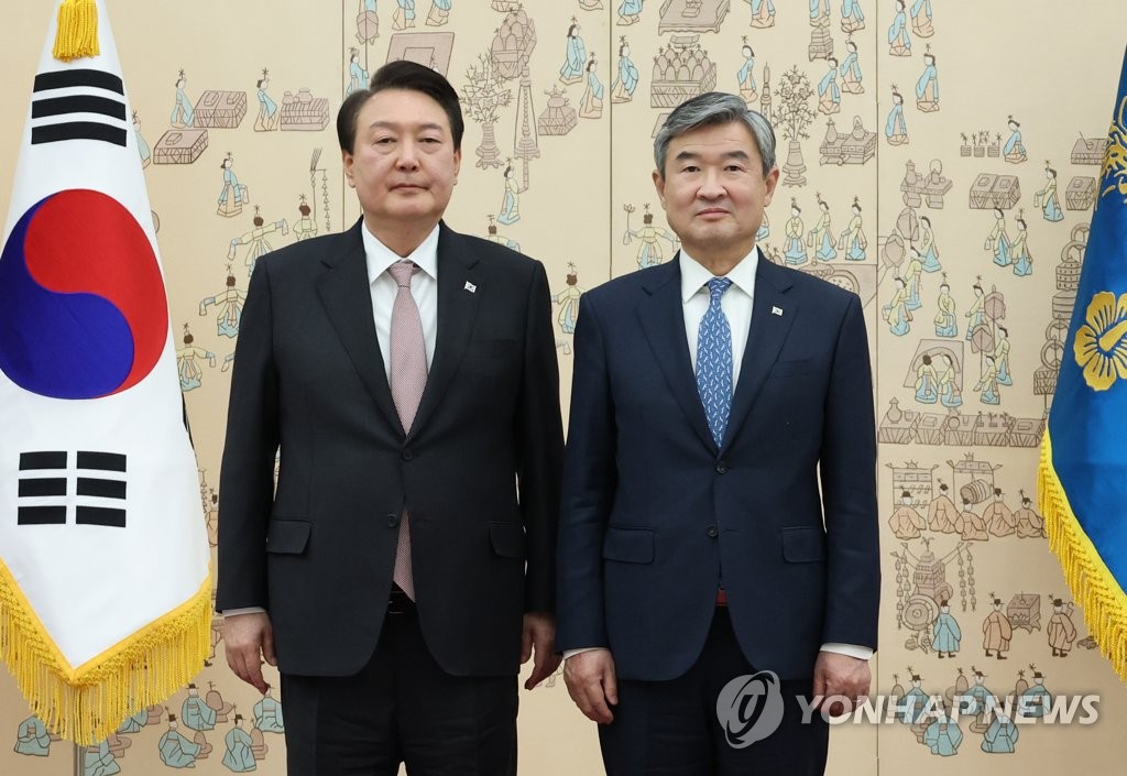 3月30日，在首尔龙山总统府，总统尹锡悦（左）向新任国家安保室室长赵太庸颁发任命书并合影留念。 韩联社