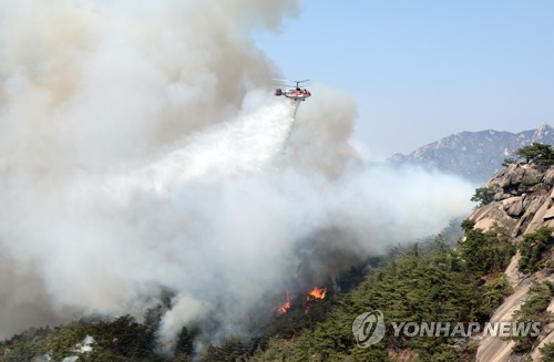 4月2日下午，在首尔市仁王山，消防直升机正在开展灭火工作。 韩联社