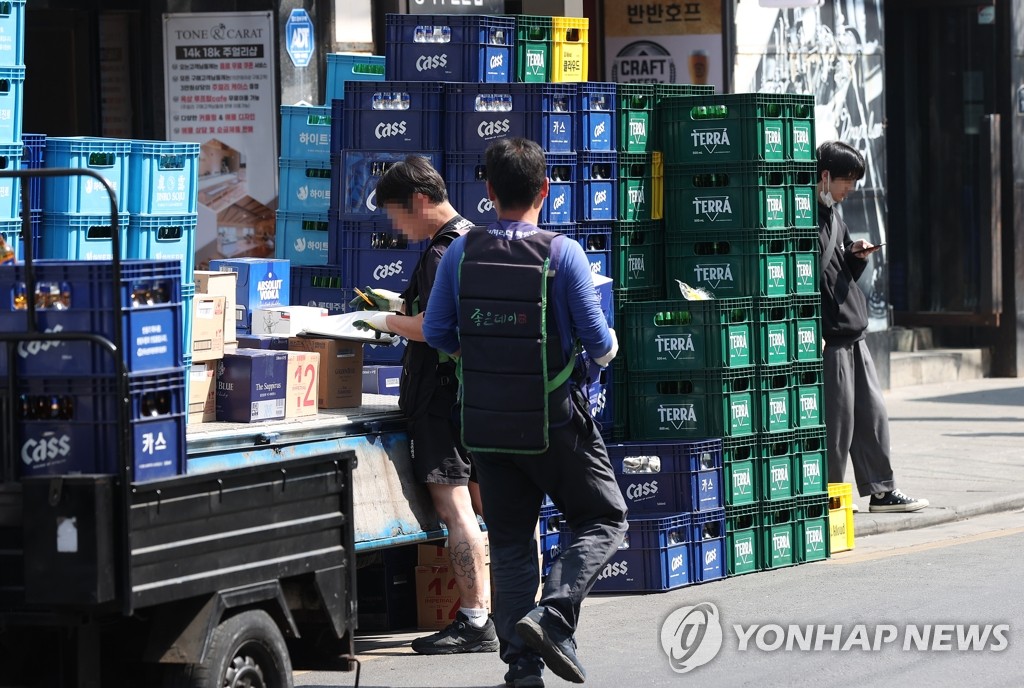 资料图片：工作人员正在搬运酒类产品。 韩联社