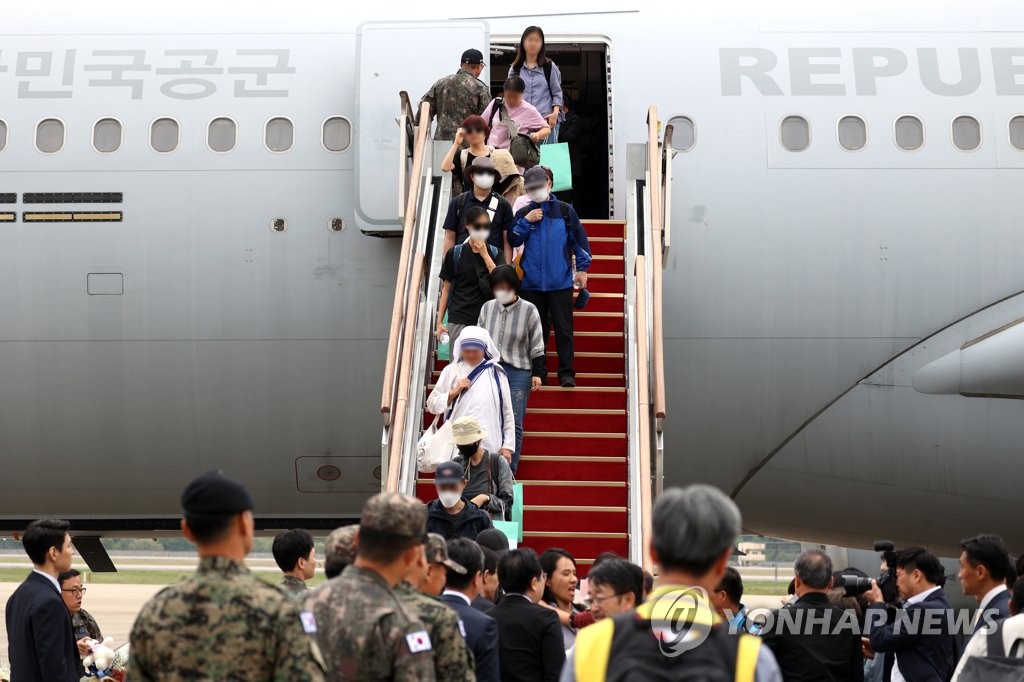 资料图片：4月25日，搭载28名旅苏韩侨的韩国空军KC-330“天鹅”加油运输机在位于京畿道城南市的首尔机场降落。图为韩侨走下舷梯。 韩联社/联合摄影记者团