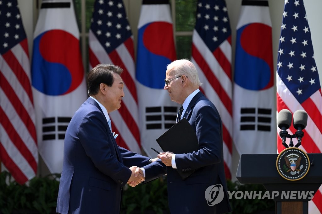 资料图片：当地时间4月26日，在美国白宫玫瑰园，韩国总统尹锡悦（左）和美国总统拜登在联合记者会上握手。 韩联社/联合记者团