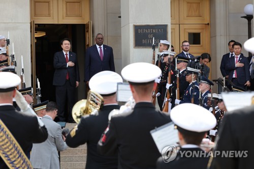 当地时间4月27日，韩国总统尹锡悦（左）访问美国国防部（五角大楼）。图为尹锡悦向国旗行礼。 韩联社