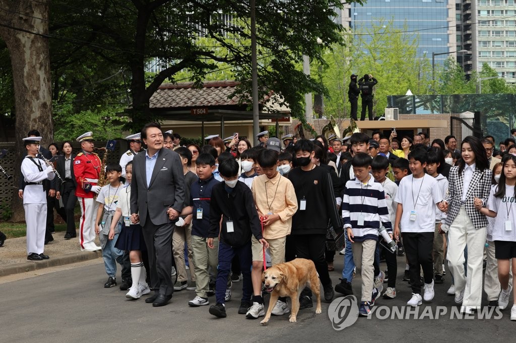 5月4日，龙山儿童庭院开放活动在首尔龙山总统府前院举行，图为总统尹锡悦和夫人金建希女士与孩子们牵手一起入场。 韩联社/总统室通讯摄影记者团