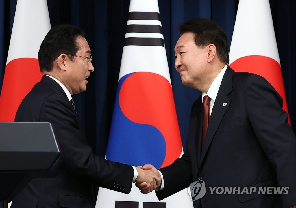 资料图片：5月7日，在龙山总统府召开的韩日首脑会谈联合记者会上，韩国总统尹锡悦（右）与日本首相岸田文雄亲切握手。 韩联社