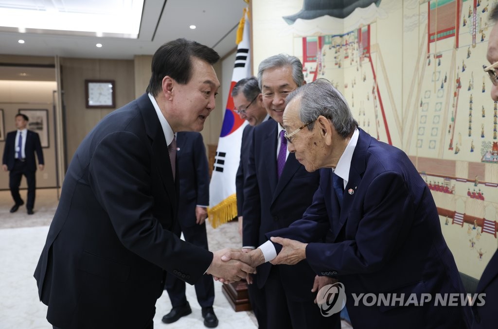 5月15日，在首尔龙山总统府，尹锡悦（左）接见韩日经济人会议的日方代表团。 韩联社/总统室供图（图片严禁转载复制）