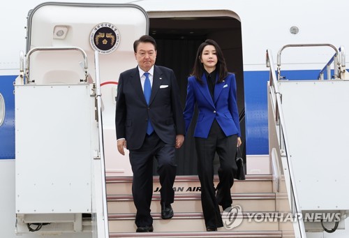 5月19日，韩国总统尹锡悦（左）和夫人金建希搭乘总统专机“空军一号”飞抵日本广岛机场。图为尹锡悦伉俪走下舷梯。 韩联社
