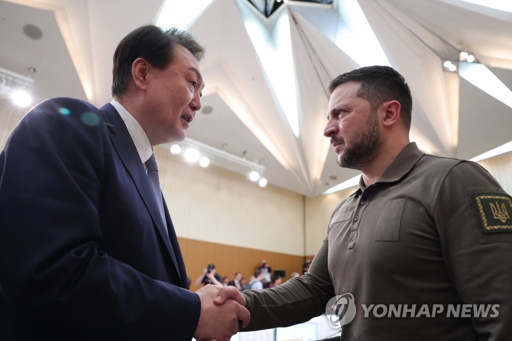 资料图片：5月21日，在日本广岛举行的七国集团（G7）峰会上，韩国总统尹锡悦（左）和乌克兰总统泽连斯基会面。 韩联社/联合采访团