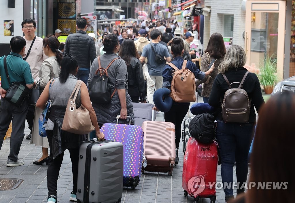 资料图片：5月21日，外国游客走在首尔明洞街头。 韩联社