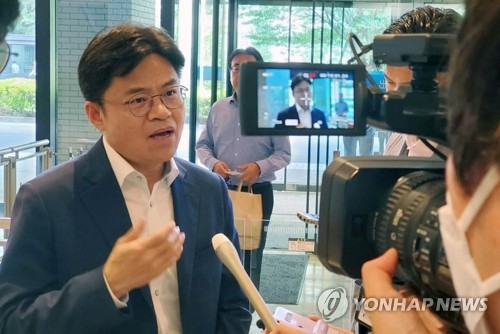 资料图片：5月22日，在日本外务省一楼大厅，刘国熙（左一）在会前接受媒体采访。 韩联社