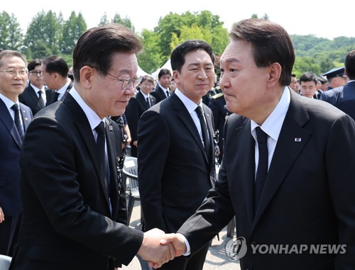 尹锡悦同民主党党首李在明握手