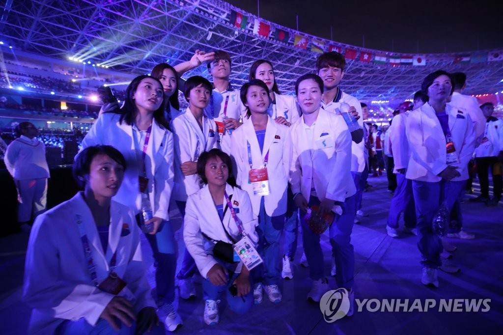 资料图片：韩朝运动员在2018雅加达亚运闭幕式上合影留念。 韩联社