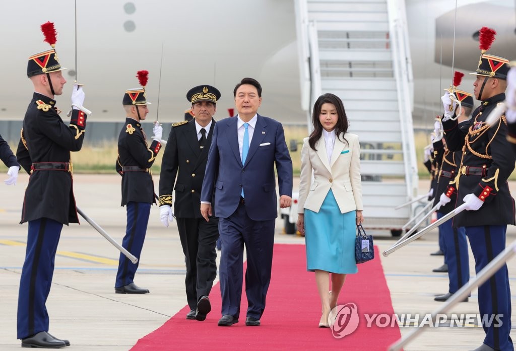 当地时间6月19日，韩国总统尹锡悦（右二）和夫人金建希（右一）乘总统专机“空军一号”抵达法国奥利机场。图为尹锡悦伉俪检阅仪仗队。 韩联社