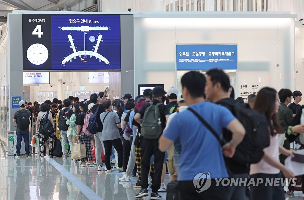 资料图片：7月2日，仁川国际机场第一客运航站楼，旅客排起长龙。 韩联社