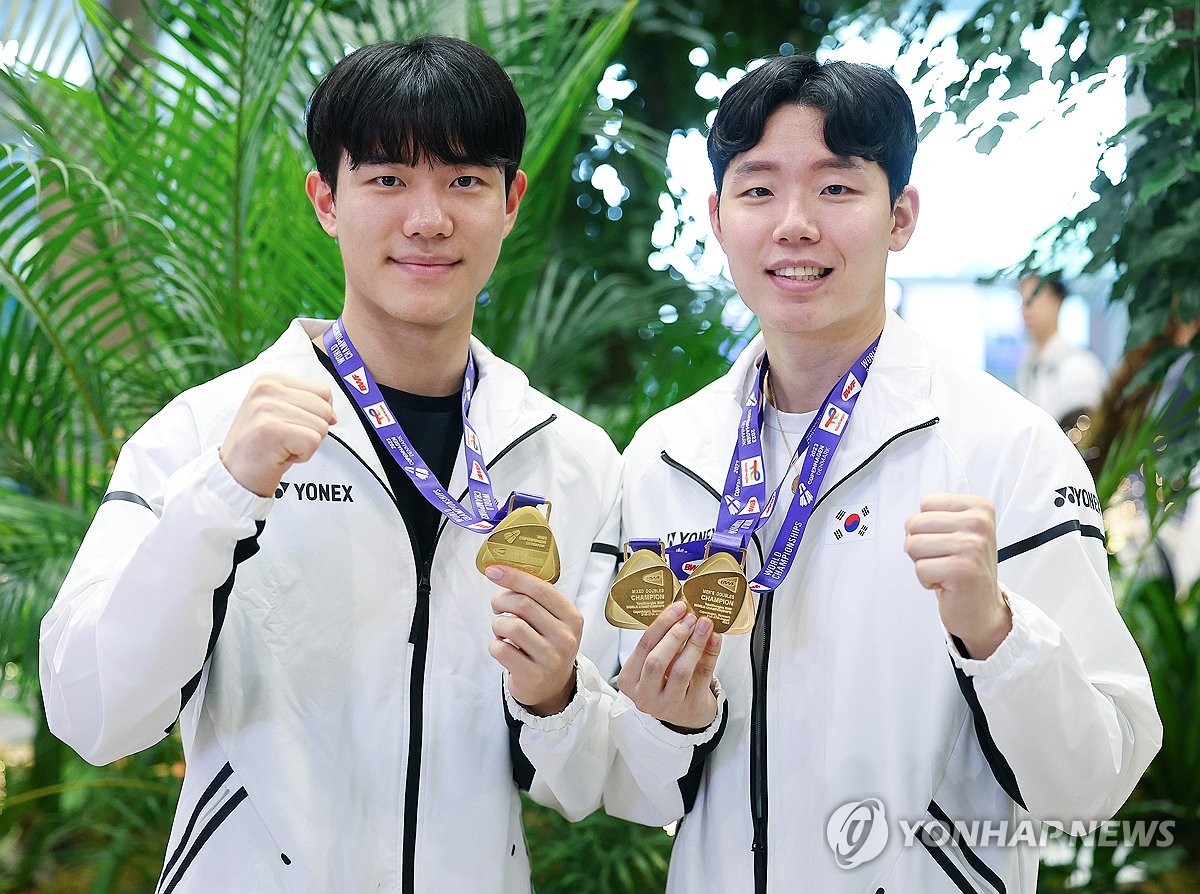 8月29日上午，在仁川国际机场，在2023年世界羽毛球锦标赛上夺得男双冠军的韩国羽毛球选手姜敏赫（左）和徐承宰亮出金牌。 韩联社