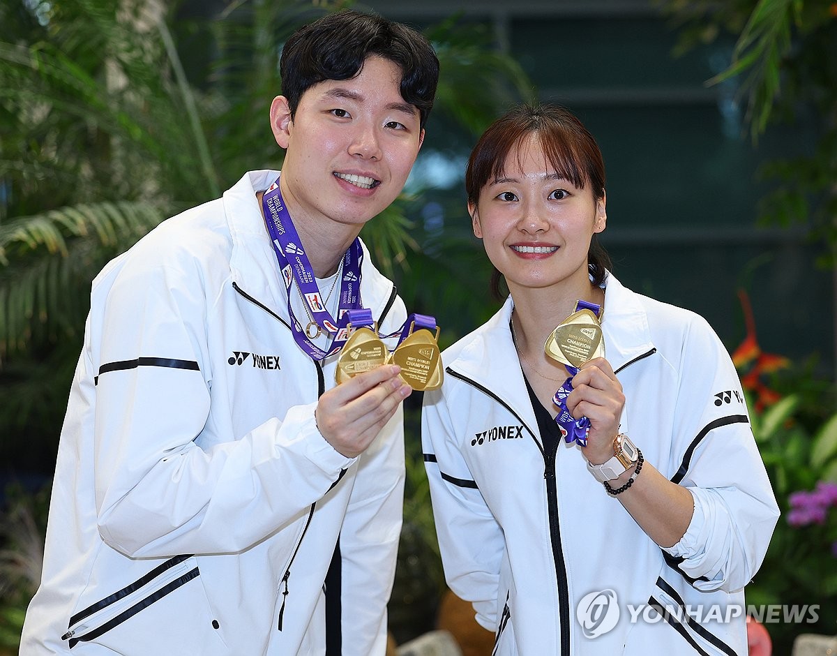 8月29日上午，在仁川国际机场，在2023年世界羽毛球锦标赛上夺得男女混双冠军的韩国羽毛球选手徐承宰（左）和蔡侑玎亮出金牌。 韩联社
