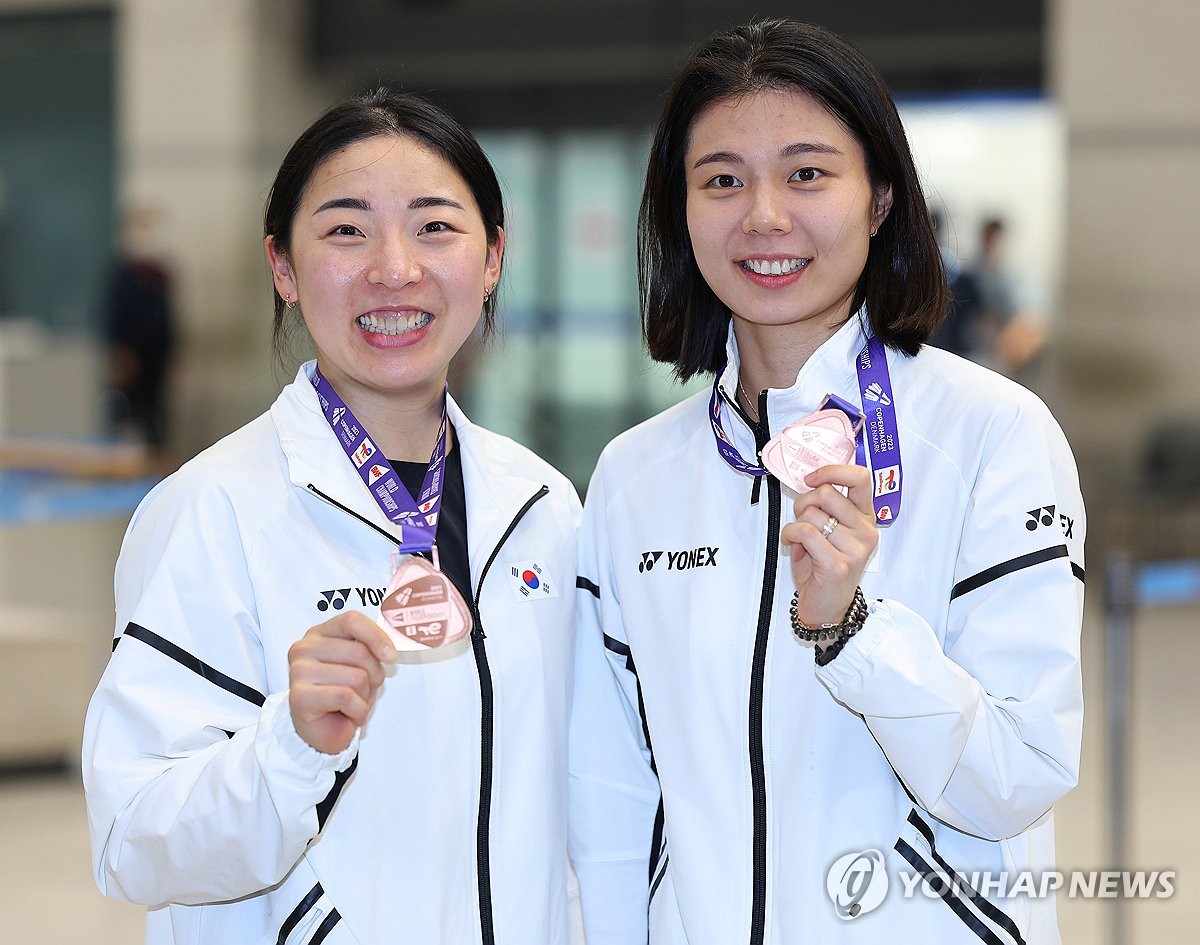 8月29日上午，在仁川国际机场，在2023年世界羽毛球锦标赛上获得女子双打铜牌的金昭映（左）和孔熙容载誉归来。图为二人举牌合影。 韩联社