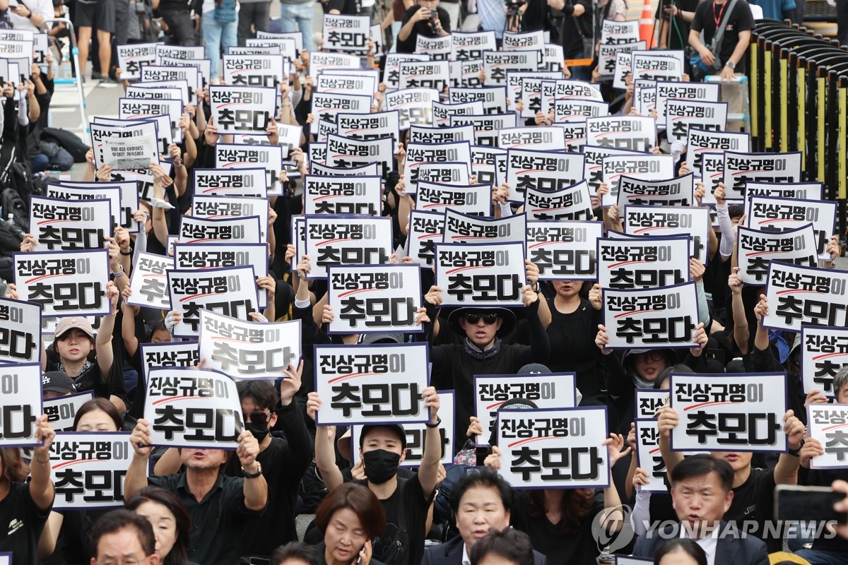 资料图片：9月4日，悼念首尔瑞二小学轻生教师的集会在首尔国会大楼前隆重举行。图为参加活动的群众手举要求查明真相的标语。当天是该教师离世后第49天。该教师于7月18日在校内轻生震惊社会，并引起全民对维护教师权利的关注。 韩联社