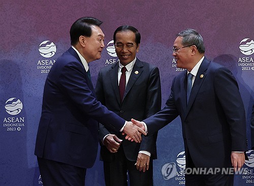 资料图片：当地时间9月6日，在印度尼西亚雅加达会议中心（JCC），韩国总统尹锡悦（左）同中国国务院总理李强（右）握手致意。 韩联社