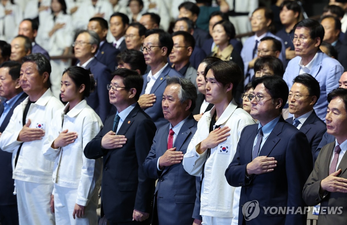 9月12日，在首尔奥林匹克公园，第19届杭州亚运会韩国体育代表团成立大会举行。图为与会人士向国旗致敬。 韩联社