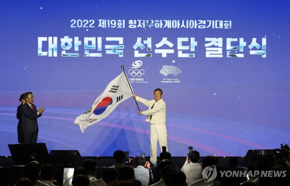 9月12日，在首尔奥林匹克公园，第19届杭州亚运会韩国体育代表团成立大会举行。图为代表团团长崔润用力挥舞韩国代表团旗帜。 韩联社 