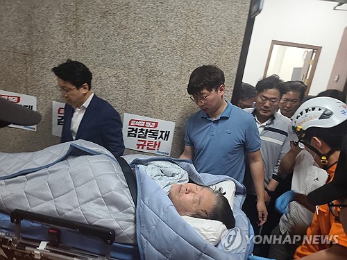9月18日，在国会，李在明被抬上担架送往医院。 韩联社