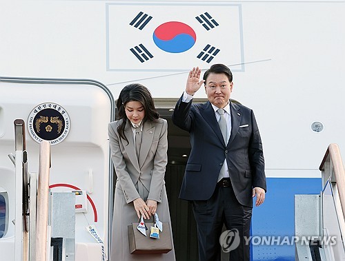 资料图片：9月18日，在城南首尔机场，韩国总统尹锡悦（右）搭乘总统专机“空军一号”启程赴美，出席第78届联合国大会。图为尹锡悦和夫人金建希向前来送行的人士致意。 韩联社