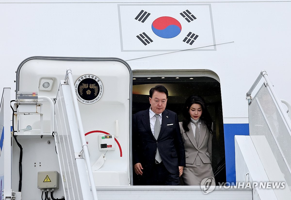 当地时间9月18日，在纽约肯尼迪机场，韩国总统尹锡悦（左）和夫人金建希女士准备下机。 韩联社