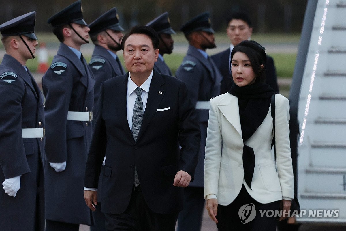 当地时间11月20日，韩国总统尹锡悦（左）和夫人金建希飞抵伦敦斯坦斯特德机场。 韩联社