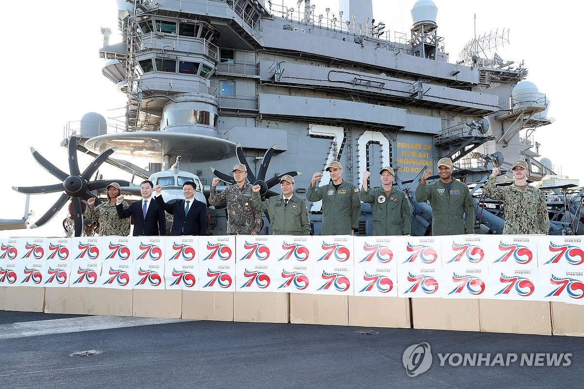 资料图片：11月22日，在釜山南区的海军作战基地，韩国国防部长官申源湜（左五）登上美国海军“卡尔·文森”号核动力航母，并与韩美国防主要人士合影。 韩联社/国防部供图（图片严禁转载复制）