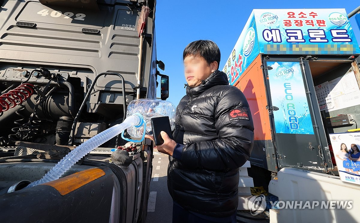 资料图片：12月4日，在仁川新港附近一处公路上，一名大型货车司机为车辆加注车用尿素溶液。中国海关总署上月30日突然叫停中方向韩企出口车用尿素溶液的通关流程，引发韩方担忧。 韩联社