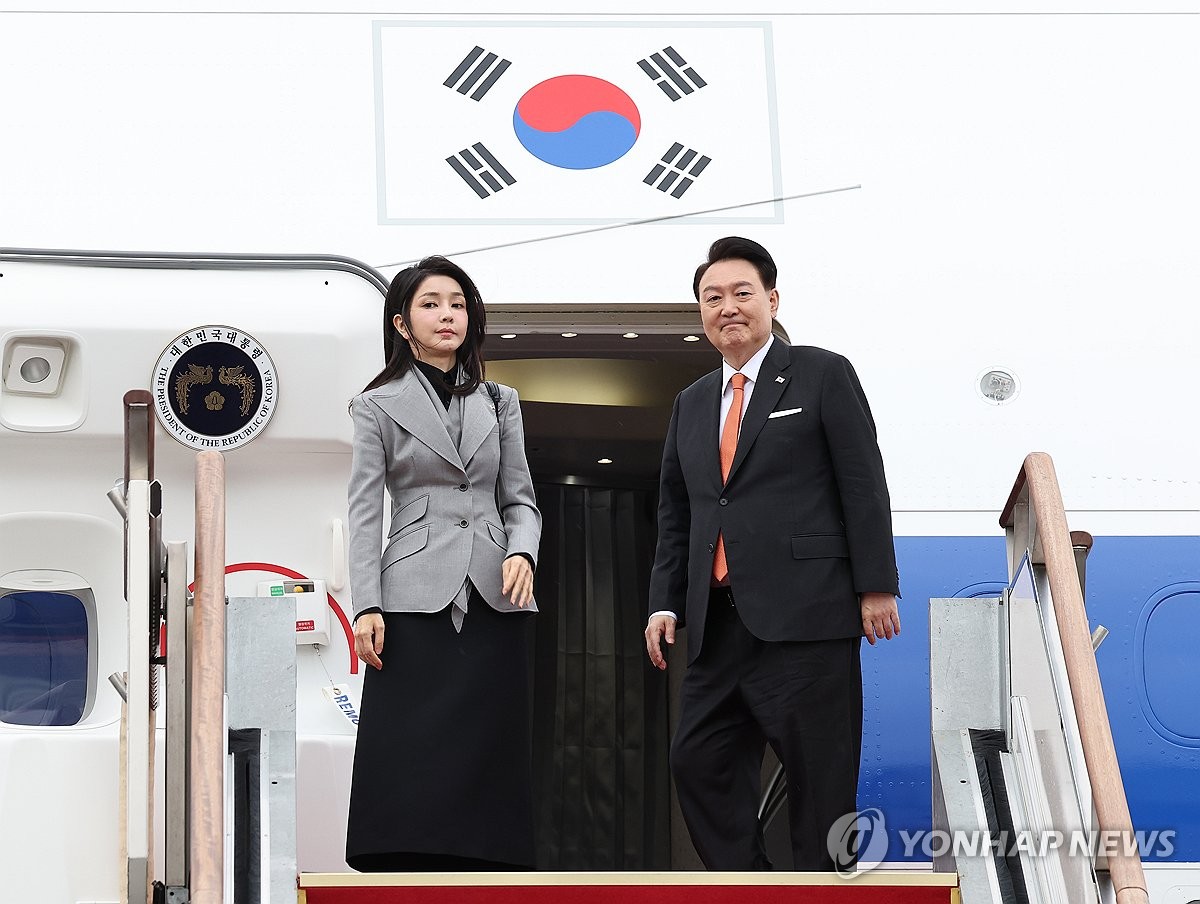 12月11日，在京畿道城南市的首尔机场，韩国总统尹锡悦（右）和夫人金建希启程赴荷兰。图为尹锡悦伉俪向前来送行的人士致意。 韩联社