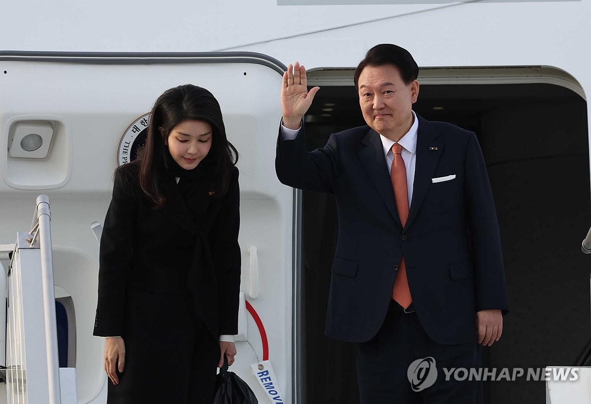 当地时间12月14日，在荷兰阿姆斯特丹史基浦机场，韩国总统尹锡悦（右）和夫人金建希搭乘总统专机“空军一号”启程返回。 韩联社
