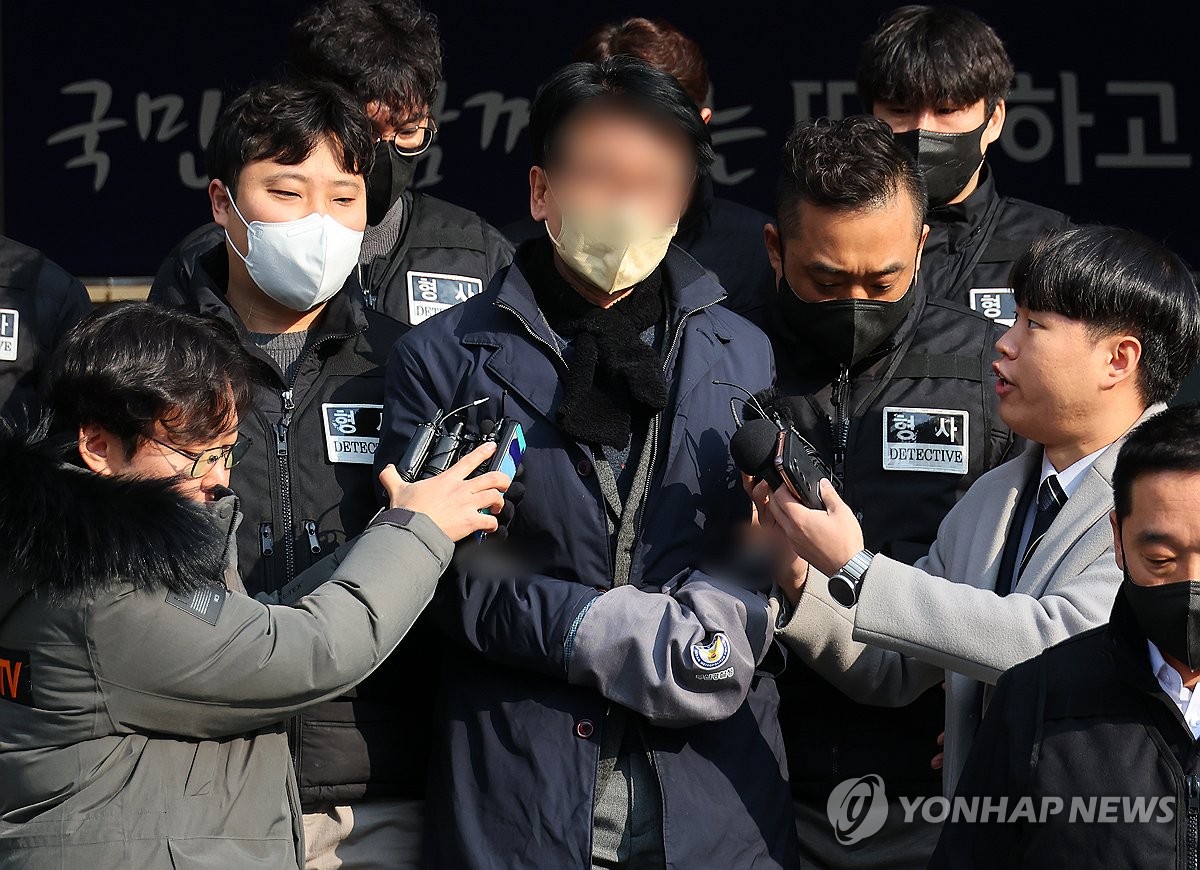 资料图片：1月10日，在釜山莲堤警察署，共同民主党党首李在明遇袭案嫌犯金某（居中）被送检。 韩联社