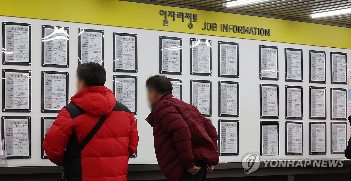资料图片：求职者查看招聘信息。 韩联社
