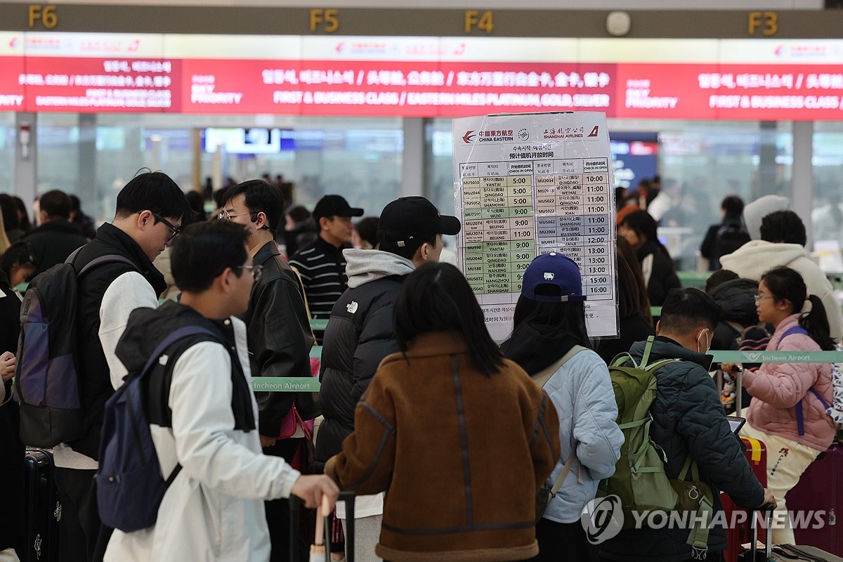 资料图片：2月18日，在仁川国际机场，旅客等待办理赴华登机手续。 韩联社