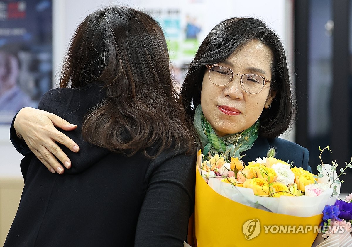 资料图片：2月21日，在中央政府首尔办公大楼，韩国前女性家庭部长官金贤淑在离任仪式上接过职员送上的花束。 韩联社