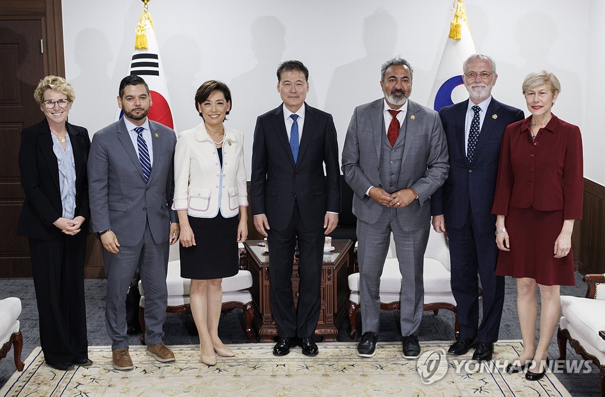 3月25日，在韩国中央政府首尔办公楼，统一部长官金暎浩（中）会见到访的美国国会韩国问题研究小组（CSGK）成员。图为金暎浩同美国联邦众议员映·金（左三）等成员们合影留念。 韩联社