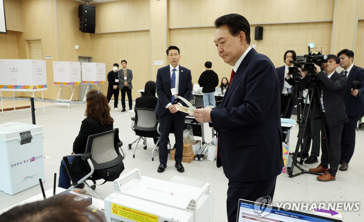 资料图片：4月5日，在釜山江西区的一处投票站，尹锡悦参加国会议员选举缺席投票。 韩联社/总统室通讯摄影记者团 