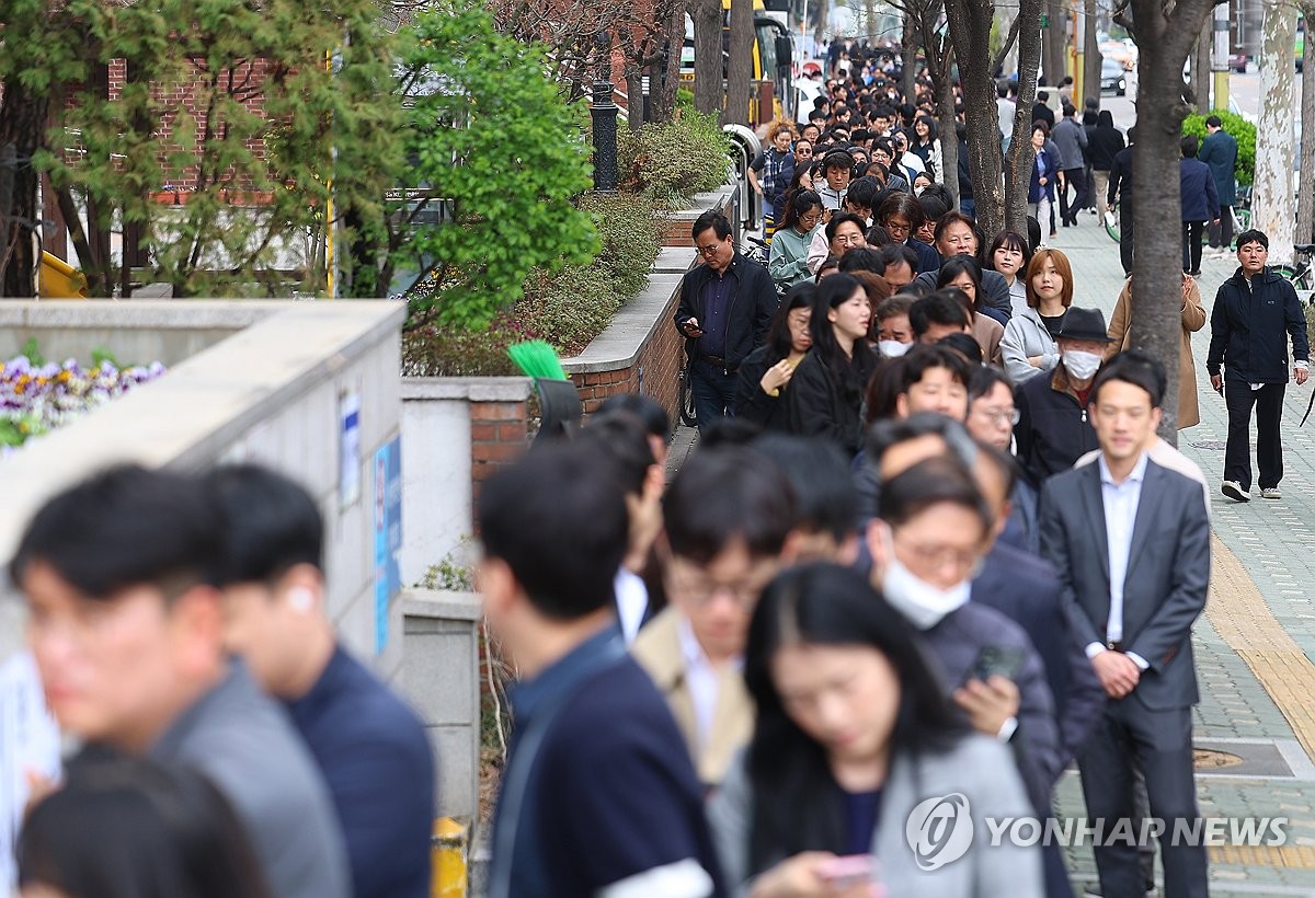 资料图片：4月5日，在首尔市汝矣洞居民中心前，上班族们利用午休时间排长队参加第22届国会议员选举缺席投票。 韩联社